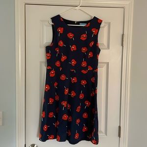 Sleeveless navy blue dress with red flowers. Hits just above the knee.